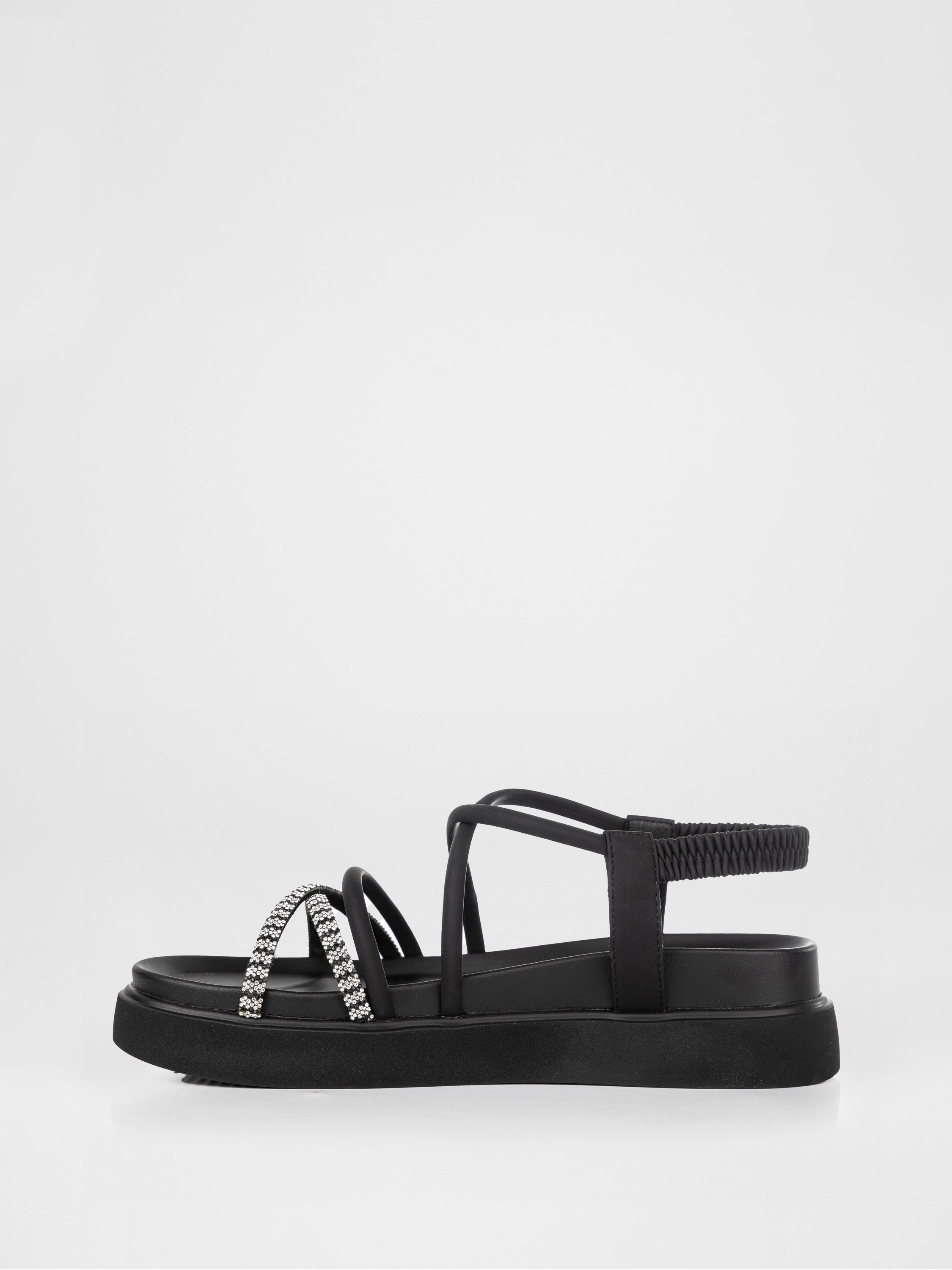 Sandalias negras de plataforma decoradas con piedras.