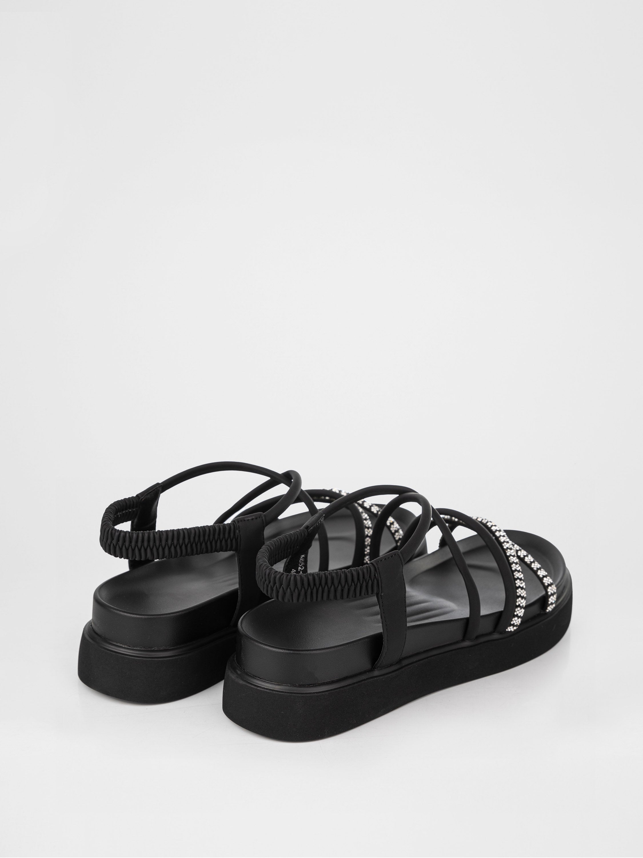 Sandalias negras de plataforma decoradas con piedras.