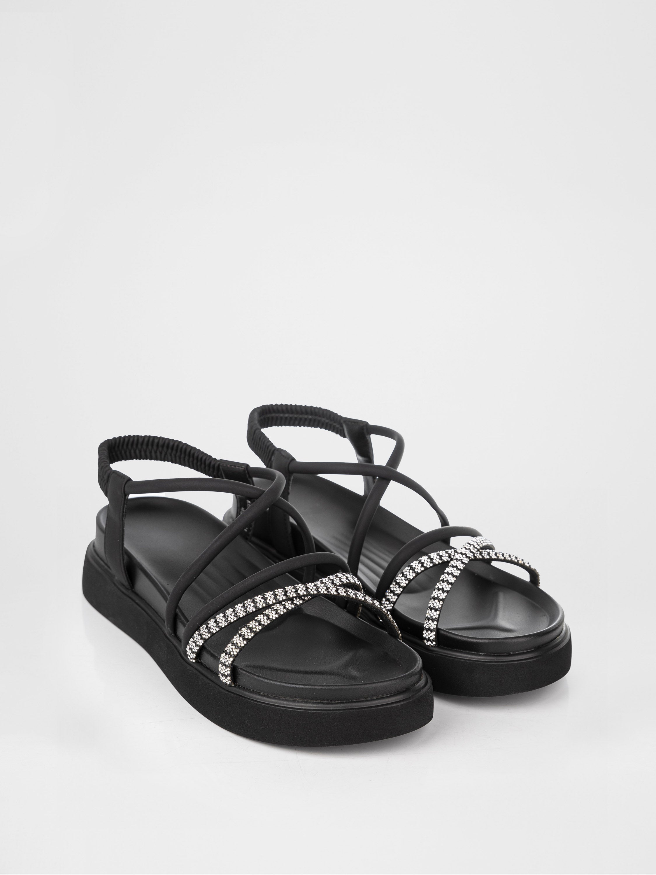Sandalias negras de plataforma decoradas con piedras.