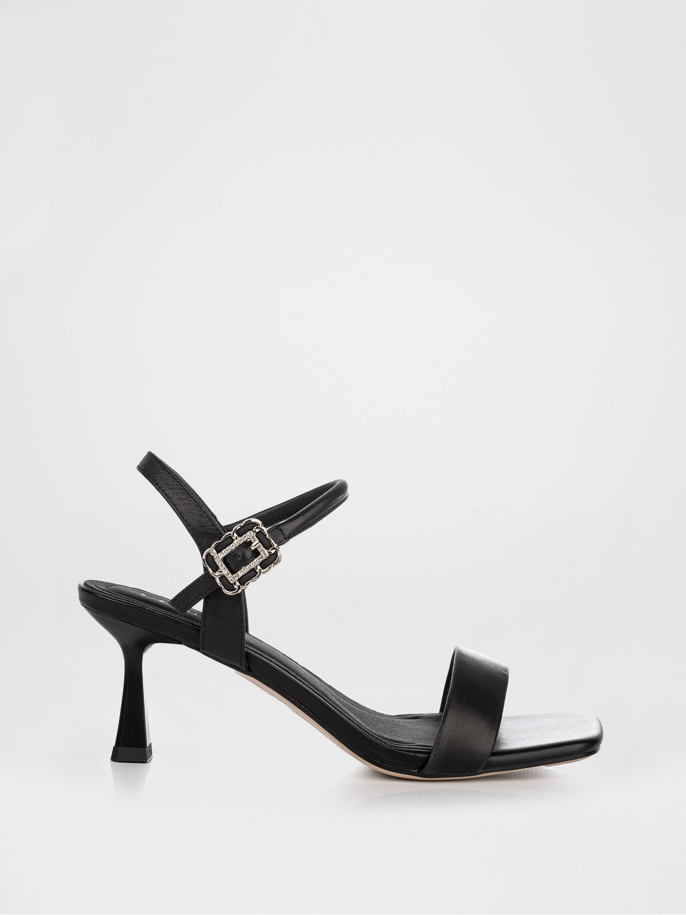 Sandalias de tacón negras decoradas con una hebilla con piedras.