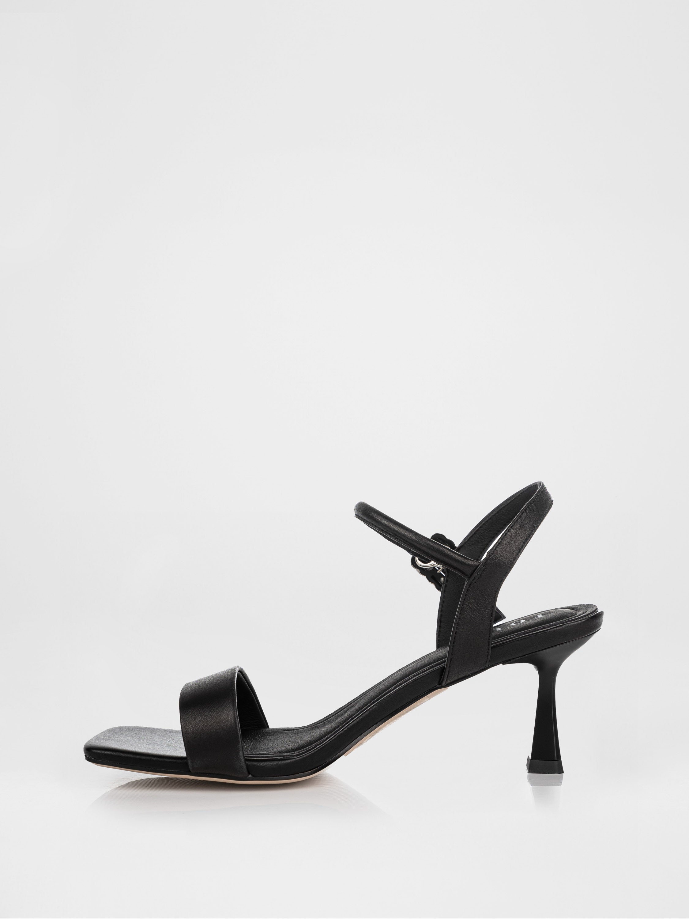 Sandalias de tacón negras decoradas con una hebilla con piedras.