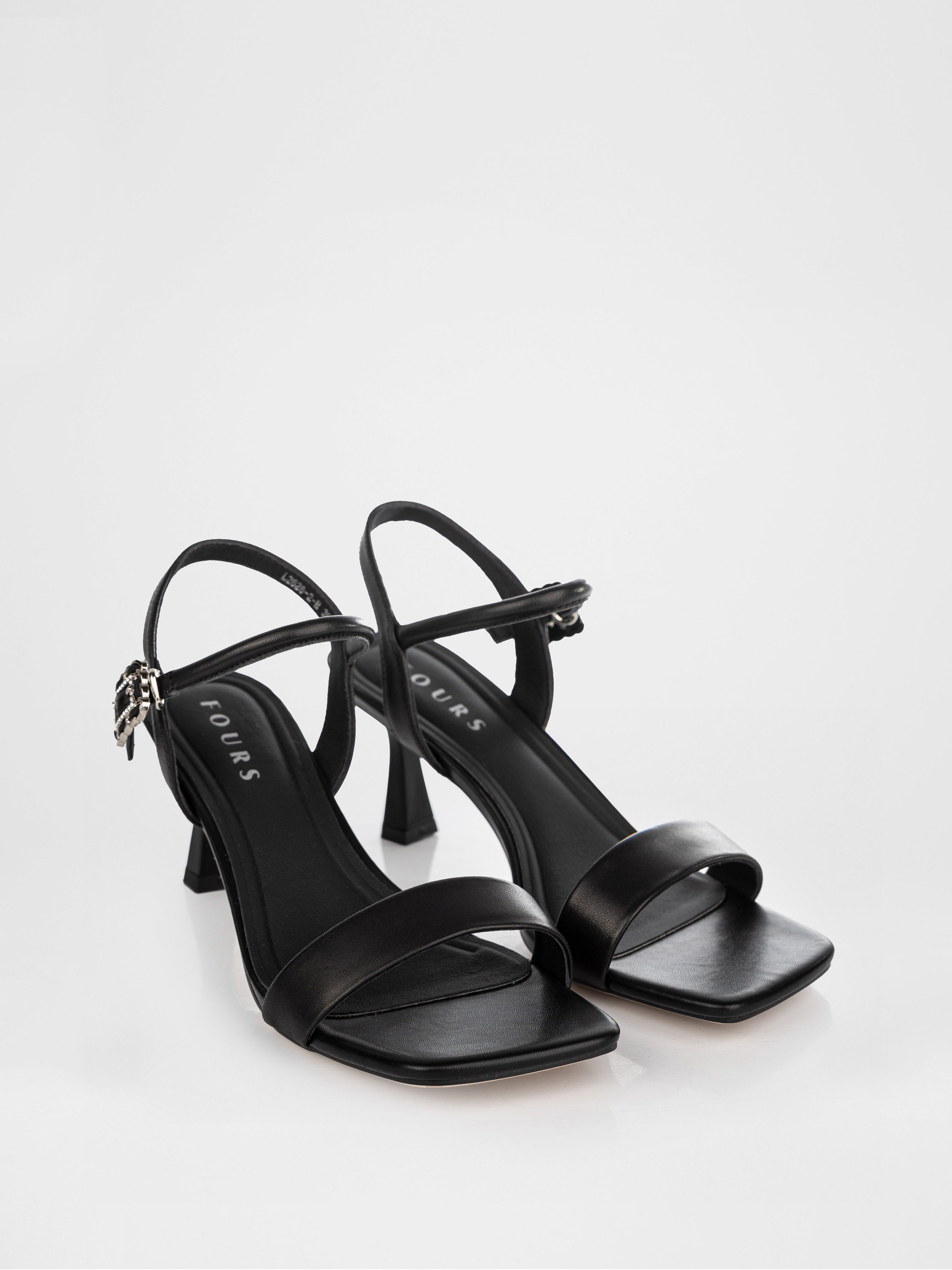 Sandalias de tacón negras decoradas con una hebilla con piedras.