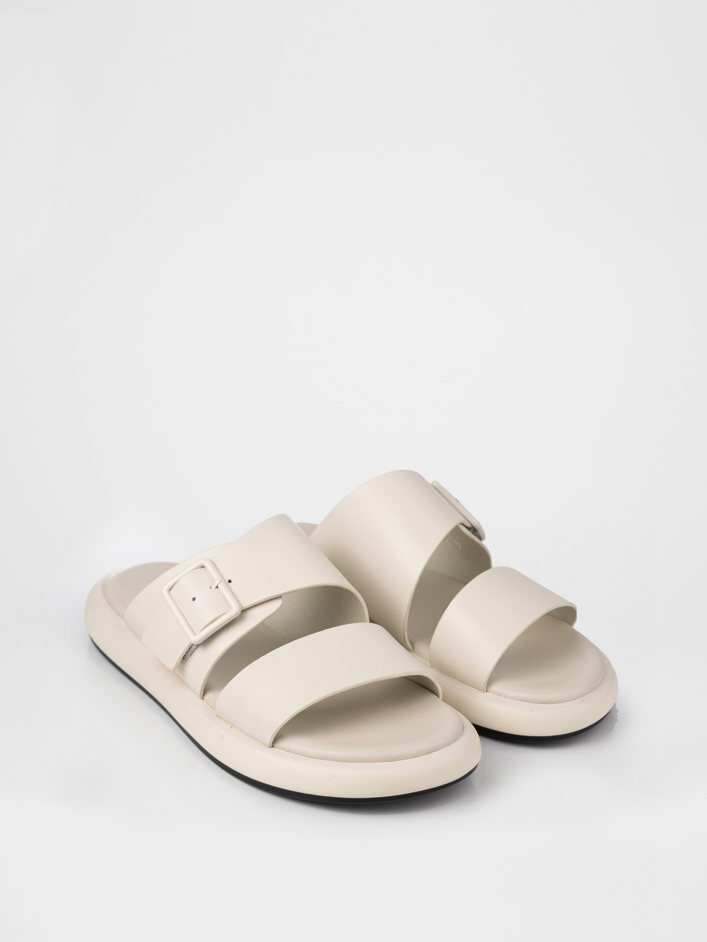 Cream-colored clogs decorated with a buckle
